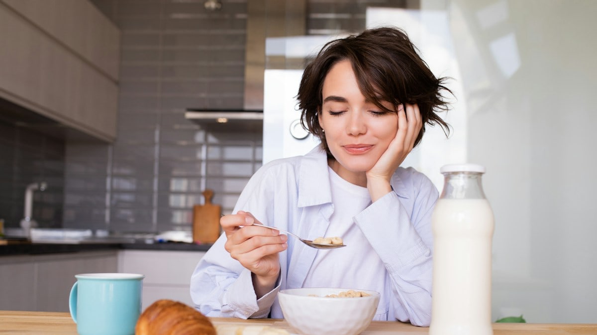 a woman sitting at a table with a plate of food